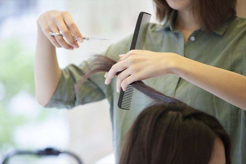 女性の髪をカットする女性美容師